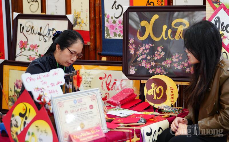 Giữa không khí rộn ràng của Hội chợ Mùa Xuân 2026, nghệ nhân thư pháp lặng lẽ gửi gắm nét chữ tới khách tham quan. Ảnh: Tô Sơn