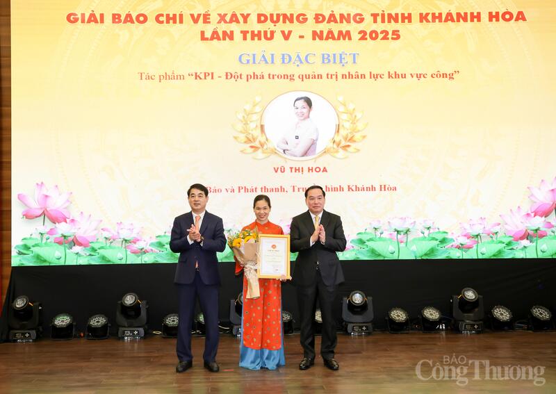 Bí thư Tỉnh ủy Khánh Hòa Nghiêm Xuân Thành tặng hoa và giấy chứng nhận cho tác giả đạt giải đặc biệt. Ảnh: Đặng Tuấn