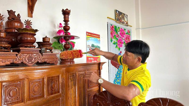 Ông Trần Chủ Nghĩa vệ sinh chỗ thờ cúng tổ tiên để chuẩn bị cho năm mới. Ảnh: Vũ Long