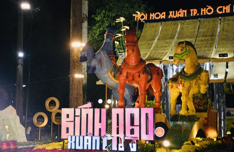 Khu vực cổng Trương Định (cổng chính) nổi bật với đại cảnh “Sắc ngọ nghinh xuân”. Bộ ba linh vật ngựa sải bước trên những dải sóng tre cách điệu - dòng chảy cội nguồn - kéo theo trống hoa lễ hội, hướng về Đền tưởng niệm các Vua Hùng, thể hiện tinh thần hướng về nguồn cội và nghênh đón phú quý. Ảnh: Minh Khuê.