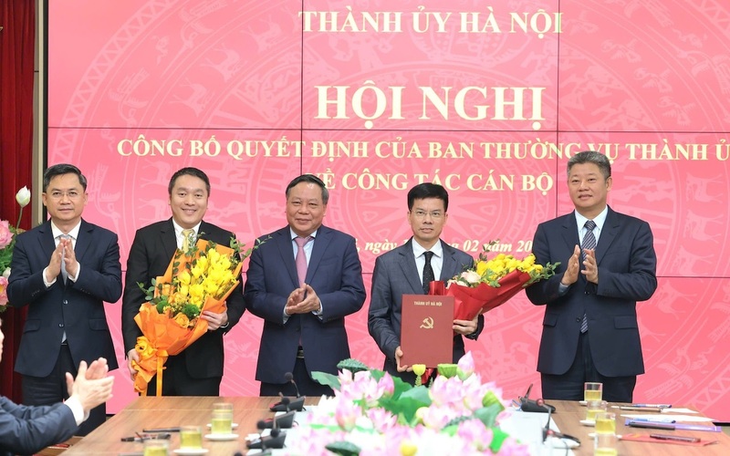 Phó Bí thư Thường trực Thành ủy Nguyễn Văn Phong và Phó Chủ tịch UBND Thành phố Nguyễn Mạnh Quyền trao quyết định và tặng hoa chúc mừng các ông Bùi Duy Cường (thứ hai từ phải sang) và Bùi Bảo Tuấn (thứ hai từ trái sang). Ảnh: Vương Vân