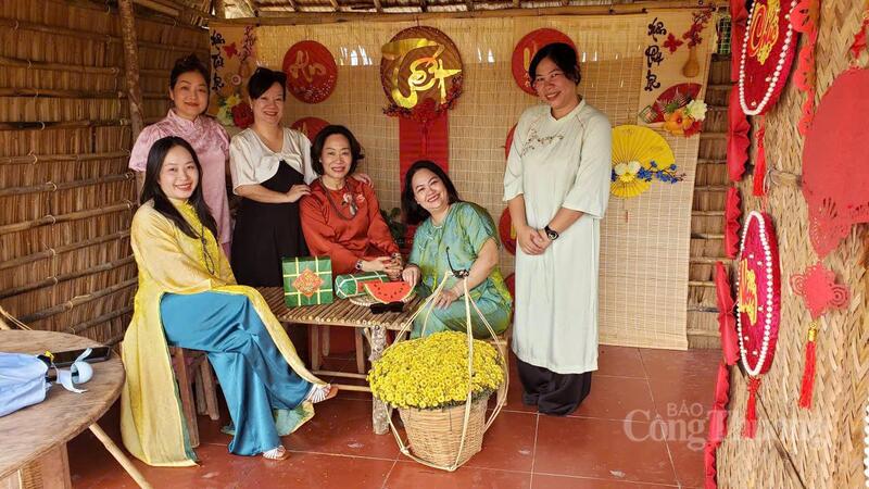 Nhóm du khách trong trang phục áo dài truyền thống check-in tại không gian bài trí Tết xưa.