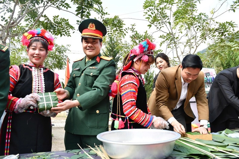 Các chiến sĩ biên phòng cùng bà con vùng đồng bào dân tộc thiểu số gói bánh chưng chuẩn bị cho tết Nguyên đán. Ảnh: CTV