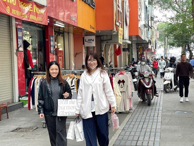 Đôi bạn Ngọc Tú và Khánh Chi (phường Kim Liên, Hà Nội) tranh thủ dịp cuối năm đi mua sắm, cho biết: “Thời điểm cận Tết là lúc các cửa hàng tặng nhiều ưu đãi, bình thường tôi hay mua sắm online để tiết kiệm thời gian, giá thành cũng tốt hơn. Nhưng khi mua online vào những dịp lễ thường sẽ giao chậm và nếu có nhận được sớm thì chưa chắc đã ưng ý hoàn toàn vì vẫn có rủi ro phải đổi trả nếu đồ bị lỗi, nên tranh thủ còn 2 ngày trước Tết, chúng tôi đến tận cửa hàng và đã mua được ba bộ đồ để diện Tết, cũng khá ưng ý”. Ảnh: Mai Linh
