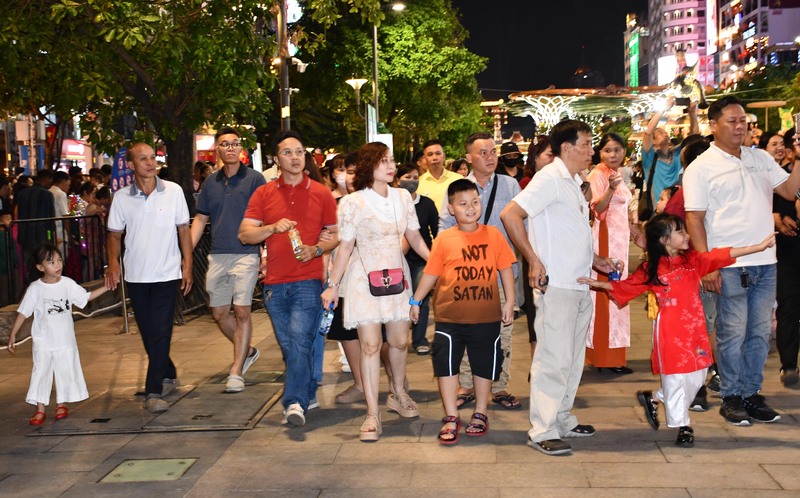 Người dân rất phấn khởi khi là những người đầu tiên được vào tham quan đường hoa Nguyễn Huệ sau lễ khai mạc tối ngày 15/2 (28 Tết). Ảnh: Minh Khuê.