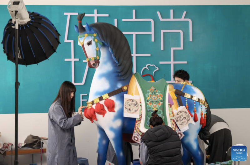 Các nghệ sĩ đang tô vẽ một tác phẩm điêu khắc bằng đất sét tại Xưởng điêu khắc. Ảnh: Xinhua