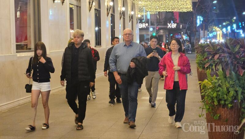 Xen giữa dòng người là các nhóm bạn trẻ, du khách quốc tế, tạo nên bức tranh sinh động, đa sắc của Hà Nội đêm 29 Tết.