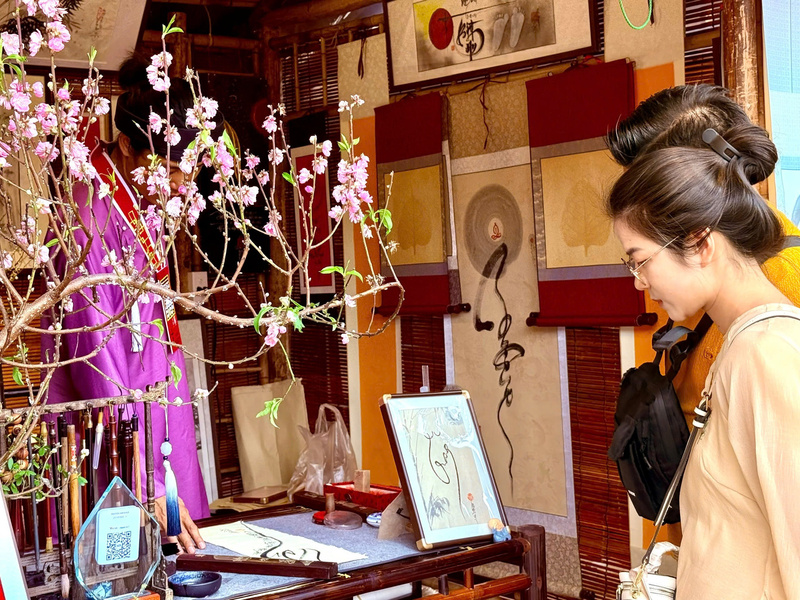 Người dân chăm chú nghe thầy đồ giải thích về ý nghĩa bức thư pháp. Ảnh: Diệu Anh