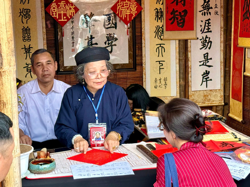 Bà đồ Hoàng Anh Diệp hướng dẫn khách chọn chữ phù hợp. Ảnh: Diệu Anh