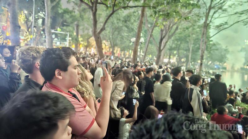 Người dân kiên nhẫn chờ đợi suốt nhiều giờ bên hồ Gươm để được chứng kiến giây phút chuyển giao thiêng liêng của năm mới.