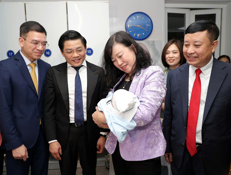 Bộ trưởng Bộ Y tế Đào Hồng Lan bế em bé vừa chào đời tại Bệnh viện Phụ sản Trung ương đêm giao thừa. Ảnh: BVCC