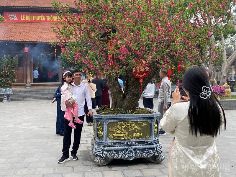 Nhiều gia đình lưu lại những bức ảnh kỷ niệm bên mái đền rêu phong, đánh dấu khoảnh khắc khởi đầu năm mới.