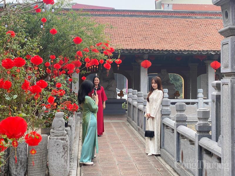 Giữa dòng người đi lễ, hình ảnh các bạn trẻ mặc trang phục truyền thống chụp ảnh góp phần tạo nên sắc xuân tại đền Tranh.