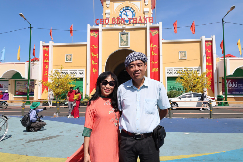 Du khách chụp ảnh lưu niệm trước cửa chính Chợ Bến Thành sáng mùng 1 Tết. Ảnh: Minh Anh