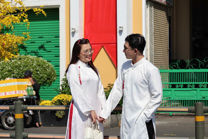 Đôi bạn trẻ chọn diện áo dài trắng đồng bộ, nắm tay nhau dạo phố và lưu giữ khoảnh khắc ngọt ngào ngày đầu năm mới tại khu vực trung tâm thành phố. Ảnh: Minh Anh