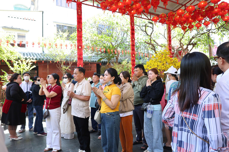 Nhiều người dân thành tâm khấn nguyện ngay từ khu vực sân chùa do bên trong chính điện đã chật kín người. Ảnh: Minh Anh