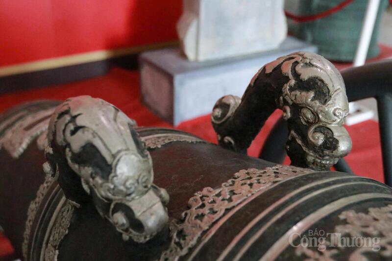 Rồng ở đây có bốn móng đuôi, đuôi xoắn cong dữ tợn theo phong cách thời Nguyễn. Các hoa cúc dây được lồng vào nhau đối xứng bao quanh súng.