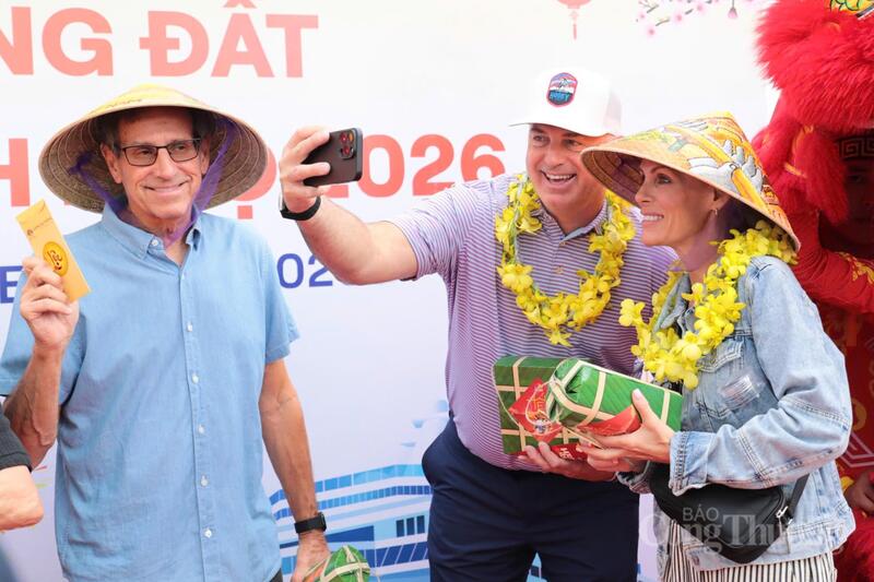 Du khách quốc tế mang nón lá, rạng rỡ với những phần quà là bánh chưng, bánh tét, bao lì xì may mắn đầu năm.