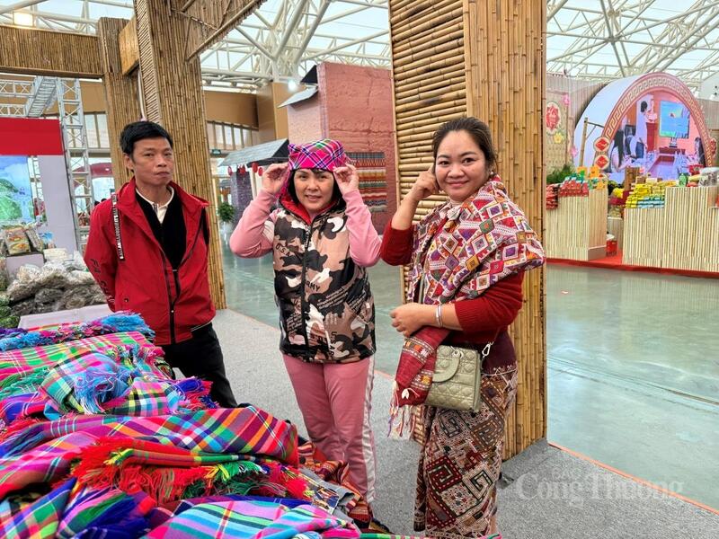 Bà Lò Thị Vân (bên phải) giới thiệu sản phẩm dệt truyền thống cho khách hàng.