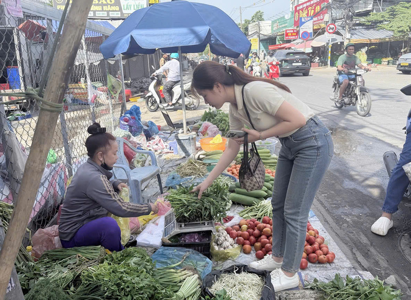 Chị Nguyễn Thu Trang (phường Long Phước) chia sẻ việc đi chợ mùng 4 khá thoải mái, giá cả rau củ ổn định và hàng hóa đầy đủ. Ảnh: Minh Anh