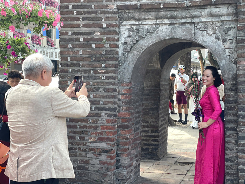 Theo ghi nhận của phóng viên, thời tiết đầu xuân khá thuận lợi với tiết trời trong xanh, nắng nhẹ, không gắt mà ấm áp, thỉnh thoảng có làn gió se lạnh dễ chịu khiến cảnh vật như bừng sáng, hòa cùng sắc áo dài của dòng người du xuân, tạo nên bức tranh Tết Hà Nội tươi tắn, rực rỡ.