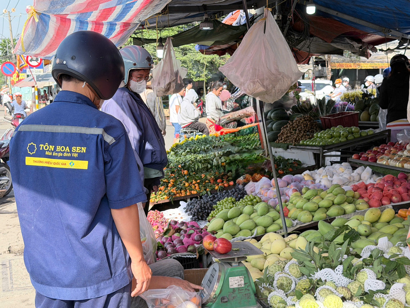 Khu vực trái cây hoạt động khá ổn định từ sớm với các mặt hàng quen thuộc như táo, xoài, thanh long phục vụ nhu cầu cúng lễ và tráng miệng. Ảnh: Minh Anh