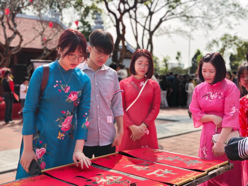 Người dân lựa chọn và ngắm các bức thư pháp với mong muốn một năm mới bình an, học tập và công việc hanh thông.
