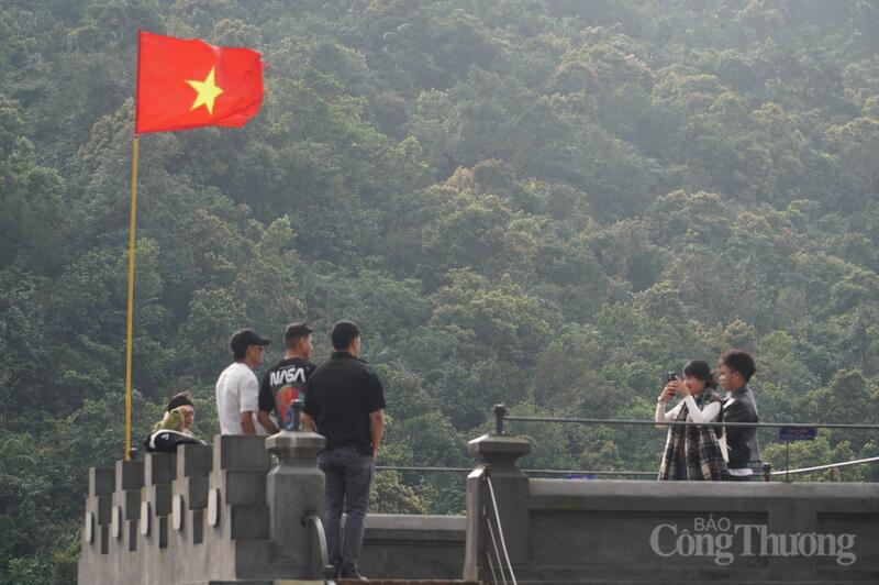 Du khách quốc tế check-in với cờ Tổ quốc Việt Nam trên đỉnh Hải Vân Quan.