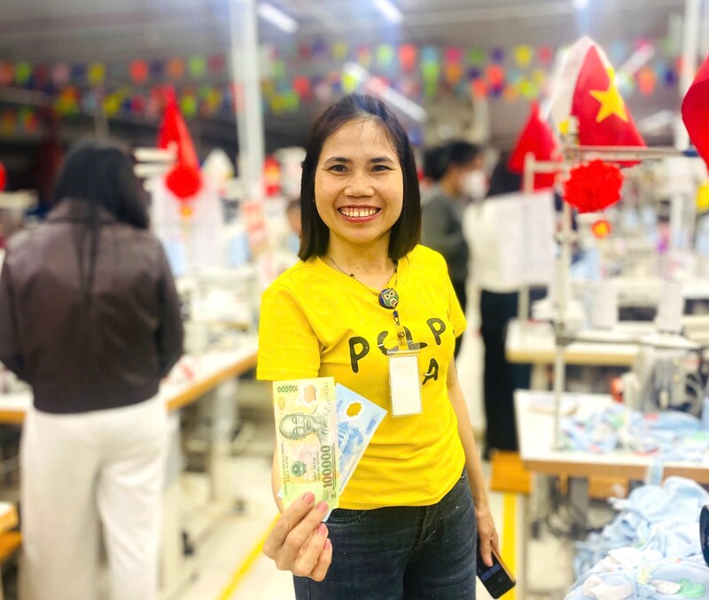 Gần 1.400 người lao động Công ty CP May Minh Anh Kim Liên nhận quà lì xì trong ngày đầu đi làm trở lại. Ảnh: Mai Liễu