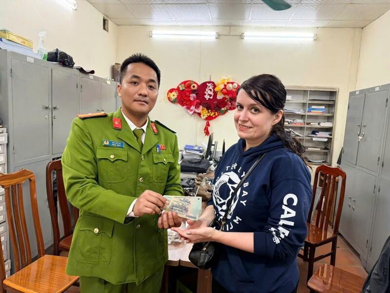 Công an phường Hoàn Kiếm trả lại tiền cho du khách. Ảnh: HK