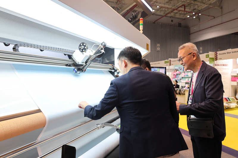 Khách tham quan tìm hiểu giải pháp kiểm tra, giám sát chất lượng vải bằng máy móc, phản ánh xu hướng "sản xuất xanh và thông minh" mà ngành dệt may đang theo đuổi.