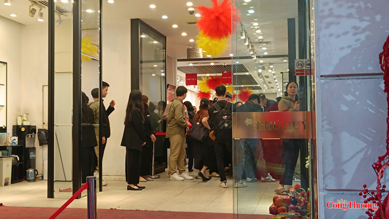 Người dân kiên nhẫn chờ đợi trong tiết trời mưa rét sáng sớm để mua vàng lấy may.