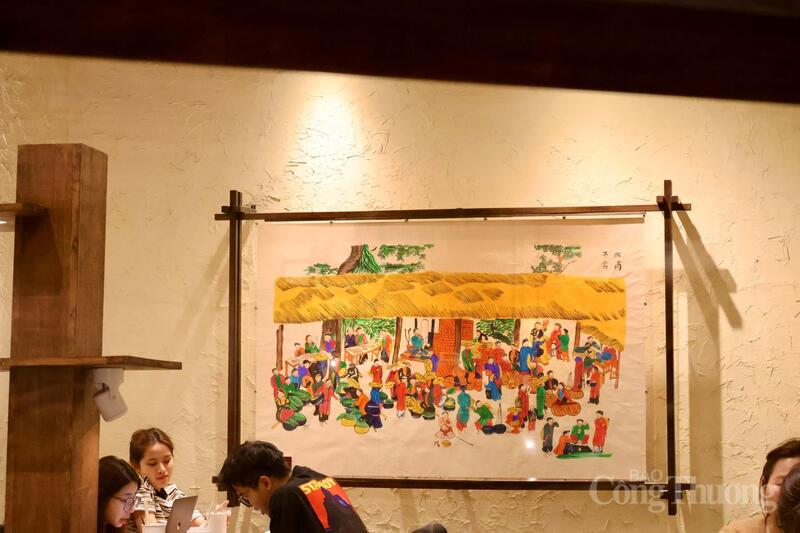 Trong các tác phẩm được trưng bày ở quán, bức tranh “Chợ quê” của nghệ nhân tranh Hàng Trống Lê Đình Nghiên là tâm điểm.