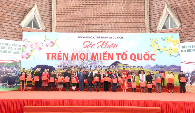 Phó Thủ tướng Mai Văn Chính và Bộ trưởng Bộ Văn hóa, Thể thao và Du lịch Nguyễn Văn Hùng tặng quà cho đồng bào các dân tộc tại sự kiện.