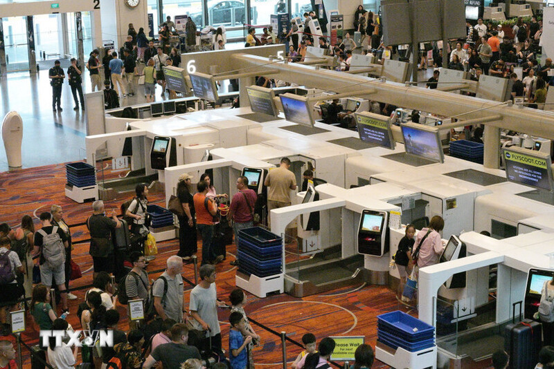 Hành khách xếp hàng tại quầy làm thủ tục ở sân bay Changi, Singapore. Ảnh:TTXVN