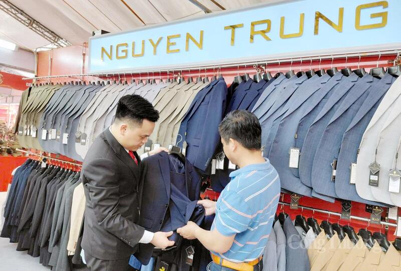 Đại diện Doanh nghiệp Nguyễn Trung (bên trái) - một cơ sở sản xuất tại làng nghề Vân Từ giới thiệu sản phẩm đến khách hàng. Ảnh: N.H