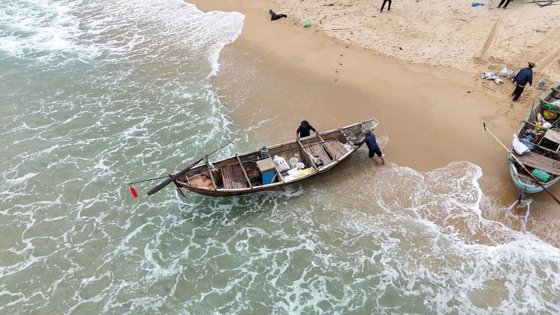 Từ sáng sớm, các ngư dân đã mang theo các dụng cụ ra bờ biển để cào ốc gạo. Ảnh: Nguyễn Dương