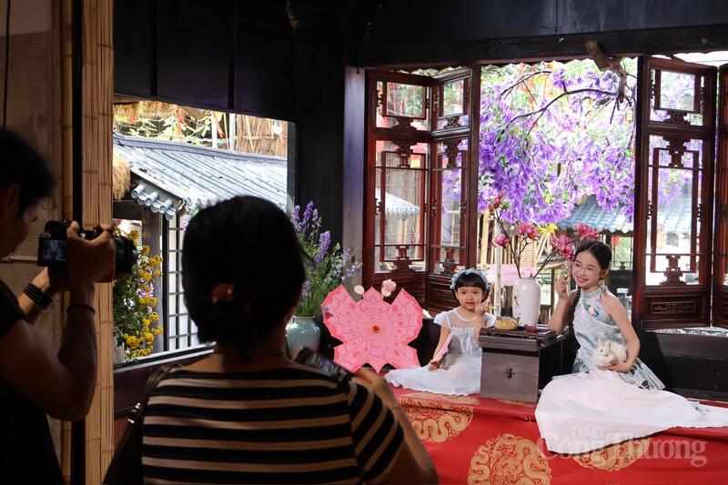 Thợ chụp ảnh hướng dẫn khách hàng cách tạo dáng bên các trang phục truyền thống của Việt Nam.