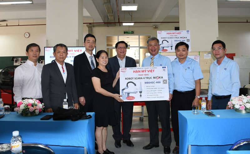 Bà Lê Thị Hồng Loan - Giám đốc Công ty TNHH Kỹ thuật Tự động Hàn Mỹ Việt trao tặng bảng xác nhận tài trợ robot MOKA cho TS. Lê Đình Kha - Hiệu trưởng Trường Cao đẳng Kỹ thuật Cao Thắng. Ảnh: Minh Khuê.