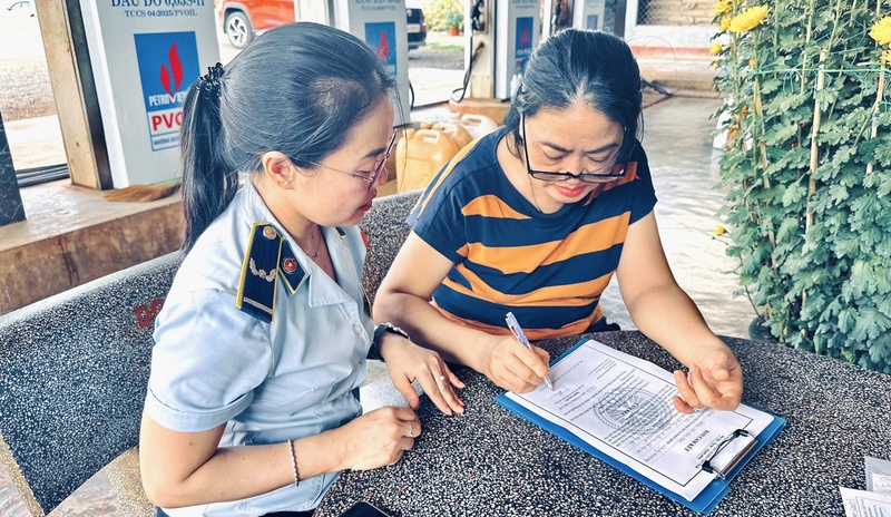Đội Quản lý thị trường số 9 tiến hành cho các đơn vị kinh doanh xăng dầu ký cam kết chấp hành nghiêm các quy định pháp luật. Ảnh: ĐVCC