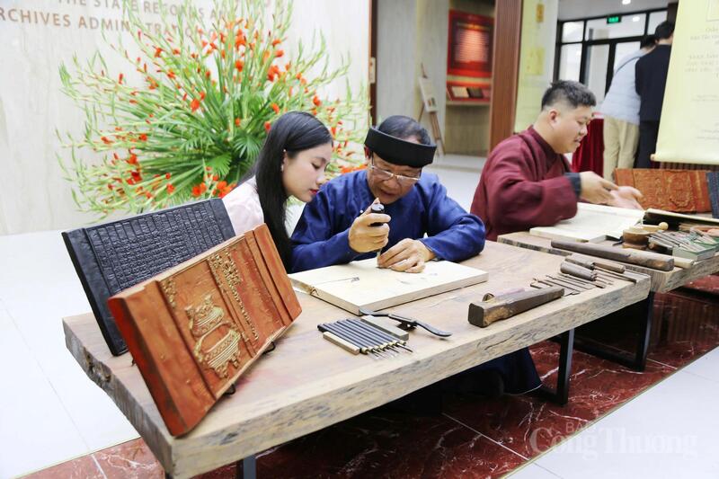 Các nghệ nhân làng Thanh Liễu trình diễn kỹ thuật khắc in mộc bản tại chương trình “Thưởng lãm Châu phê - Mộc bản”. Ảnh: Bảo Thoa