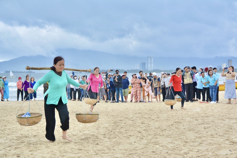 Trò chơi gánh cá tạo không khí sôi động, thu hút đông đảo người dân cổ vũ. Ảnh: Ngọc Thảo