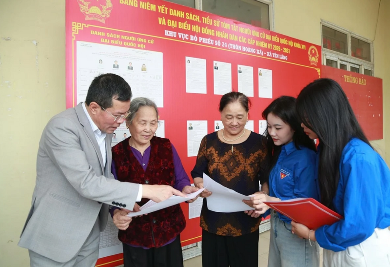 Ông Lỗ Xuân Hòa, Phó Bí thư Thường trực Đảng ủy, Chủ tịch Ủy ban MTTQ xã Yên Lãng (ngoài cùng bên trái) trao đổi về quy định bầu cử với cử tri. Ảnh: Phạm Hùng