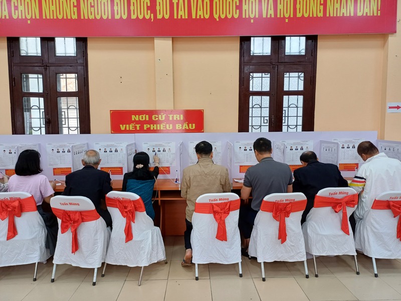 Cử chi viết phiếu bầu tại khu vực bầu cử.