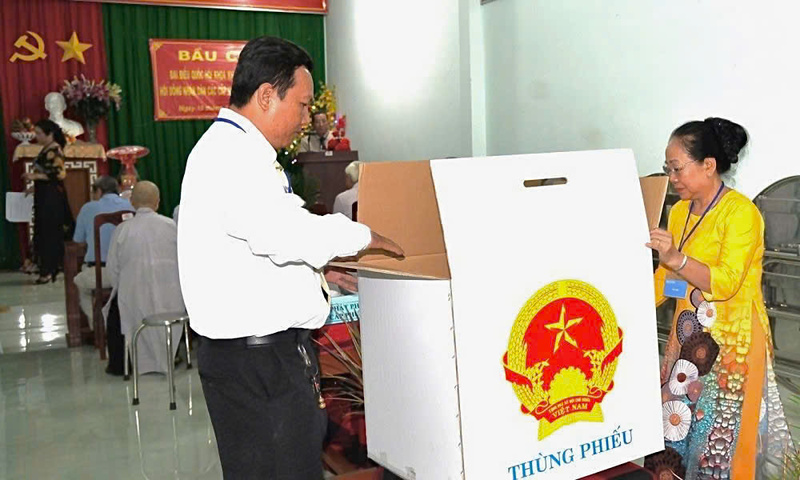 Các thành viên Tổ bầu cử phối hợp kiểm tra hòm phiếu trống và niêm phong trước sự chứng kiến của cử tri. Ảnh: Lê Minh