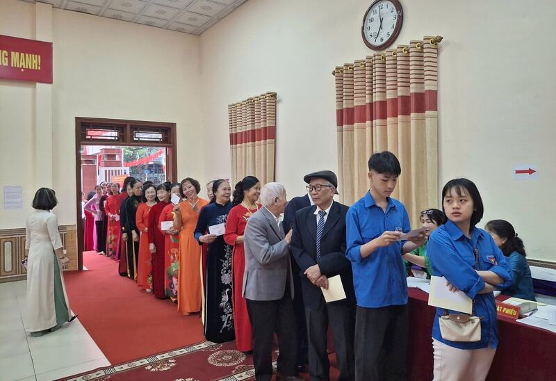 Cử tri phường Việt Hưng xếp hàng chờ vào khu vực bỏ phiếu.