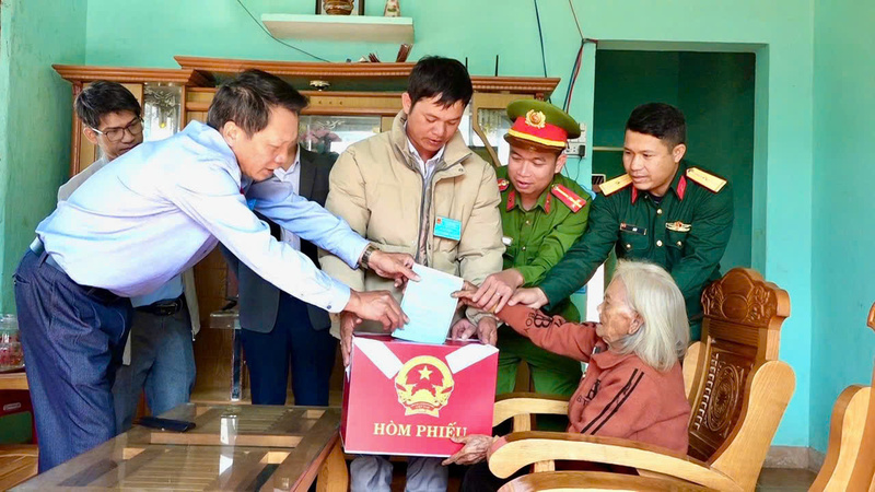 Chính quyền địa phương xã Tu Mơ Rông đem thùng phiếu đến nhà Mẹ Việt Nam anh hùng Y Tría để mẹ bỏ phiếu. Ảnh: Nguyễn Dương