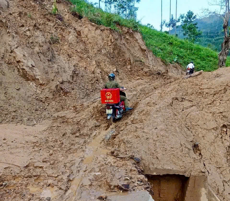 Mưa lớn liên tục mấy ngày khiến cho nhiều khu vực của xã Tây Trà Bồng bị sạt lở, lầy lội. Các cán bộ xã phải vượt con đường bùn lầy để đem thùng phiếu đến cho những hộ dân sức khỏe yếu, không thể đến điểm bầu cử. Ảnh: Nguyễn Dương
