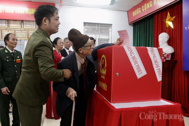 Các cụ cao tuổi đi lại khó khăn được thành viên tổ bầu cử tận tình hỗ trợ vào khu vực bỏ phiếu.