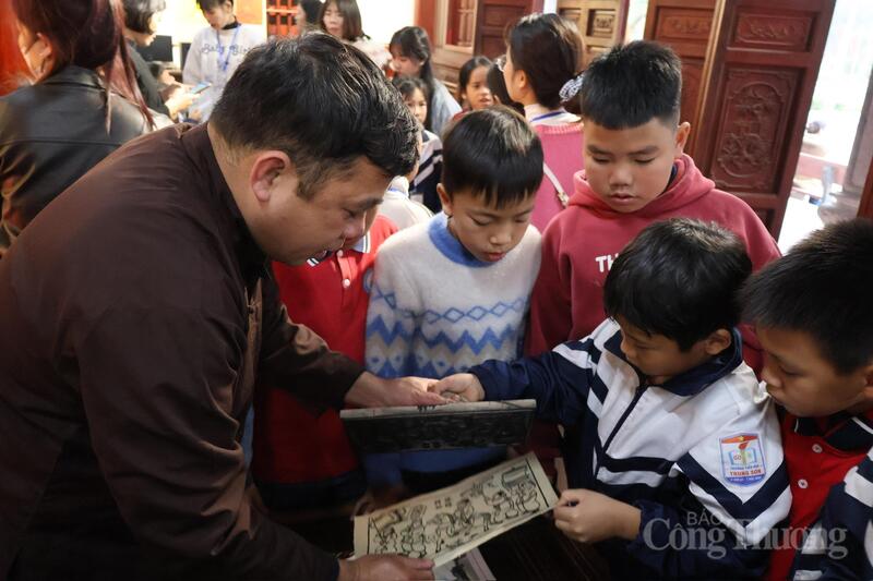 Các em nhỏ hào hứng quan sát quy trình làm tranh Đông Hồ. Ảnh: Phương Hà